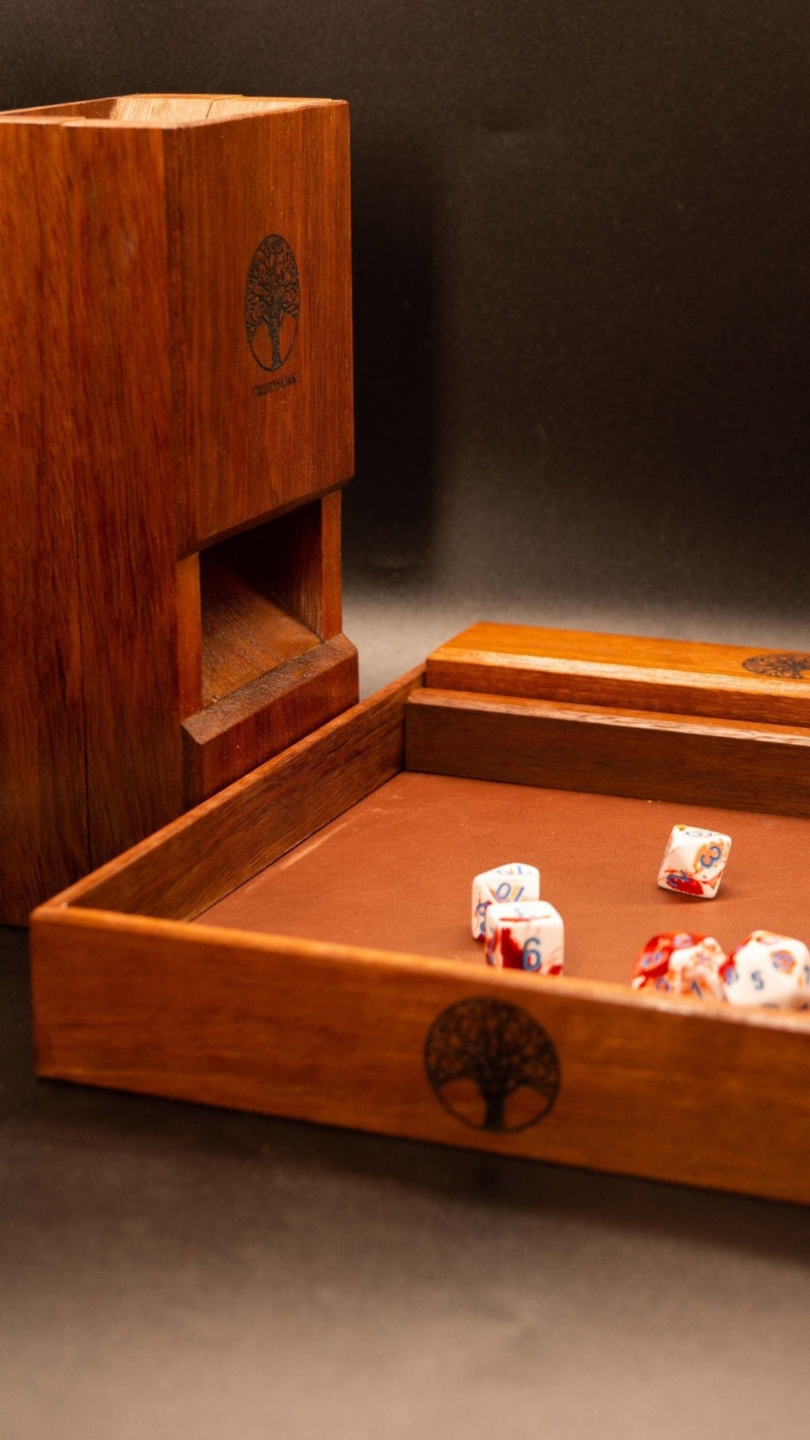 The jarrah tabletop gaming set includes matching tray with leather lining and rubber feet, dice vault and dice tower. The tower can be broken into two halves in stored neatly within the tray. The dice vault also fits neatly for easy storage.